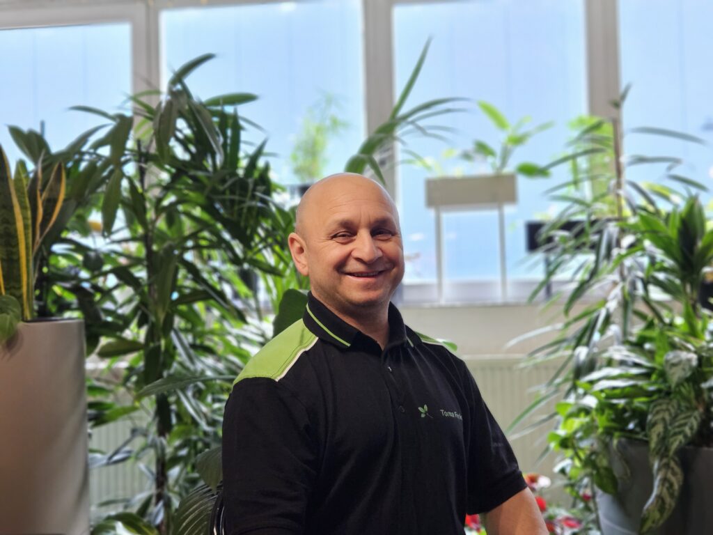 Foto von Mitarbeiter Toma Ferkovic zwischen Pflanzen.