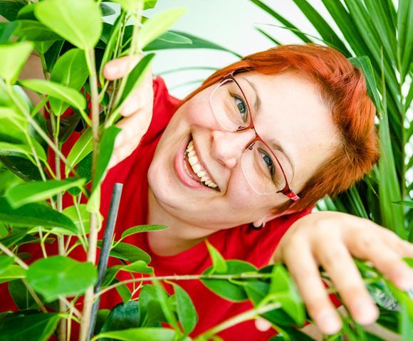 Foto von Mitarbeiterin Daniela Künne-Schürmann zwischen Pflanzen.